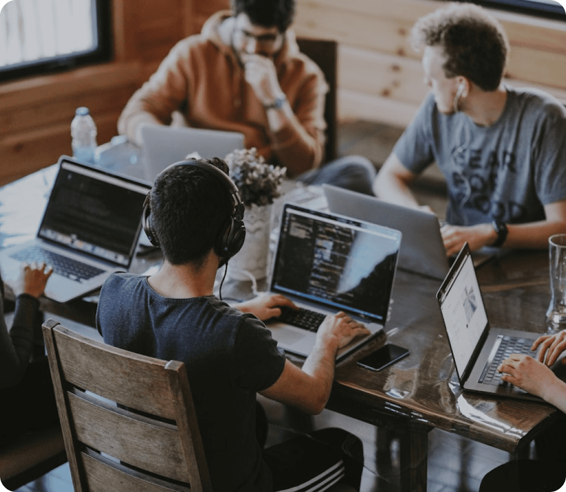 Professionals collaborating on laptops around a shared table