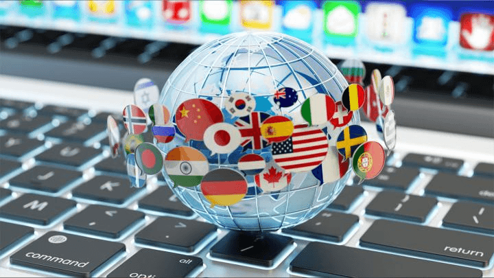 Glass globe covered in national flags on a laptop keyboard